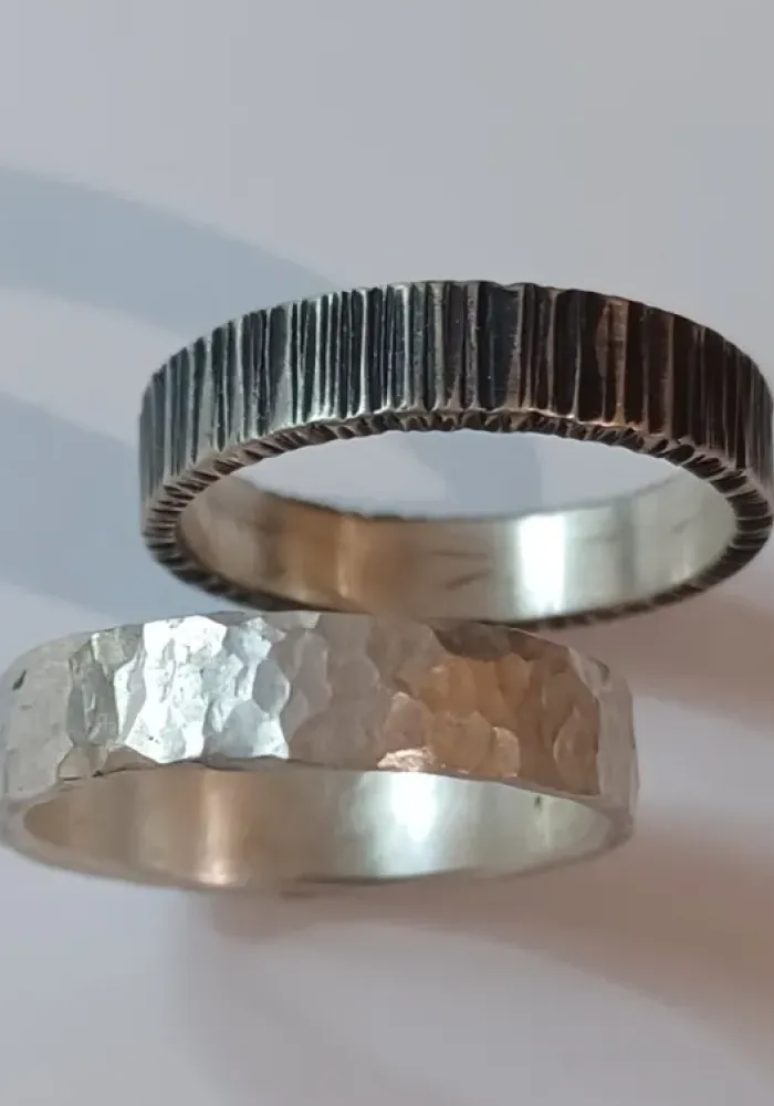 Atelier 3 Deux alliances en argent aux textures martelées et rainurées fabriquées dans un atelier de bijoux à Montpellier.