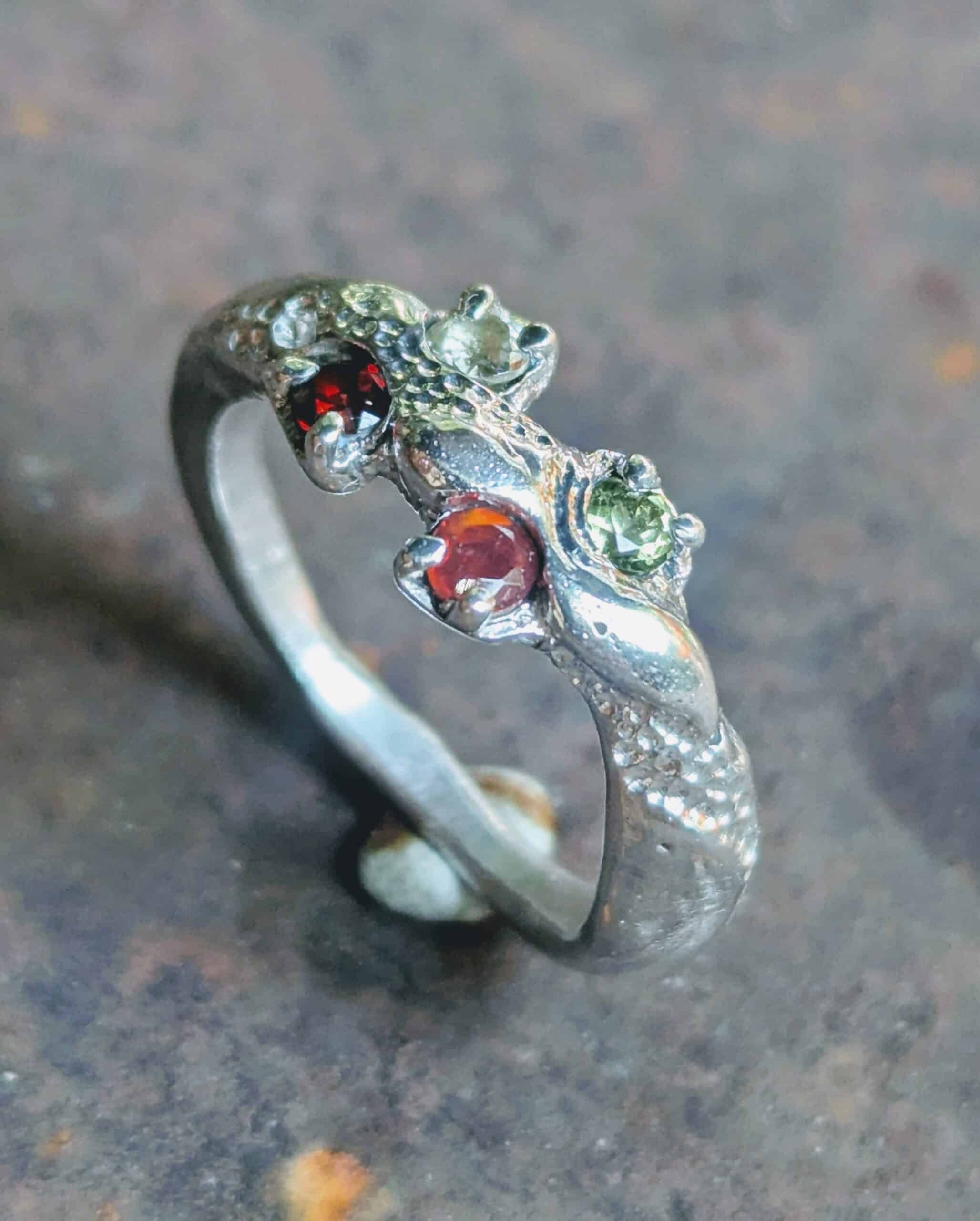 Bague Artisanale en Argent avec Grenats et Péridots Bague en argent texturé sertie de deux grenats rouges et deux péridots verts, design organique fait main.