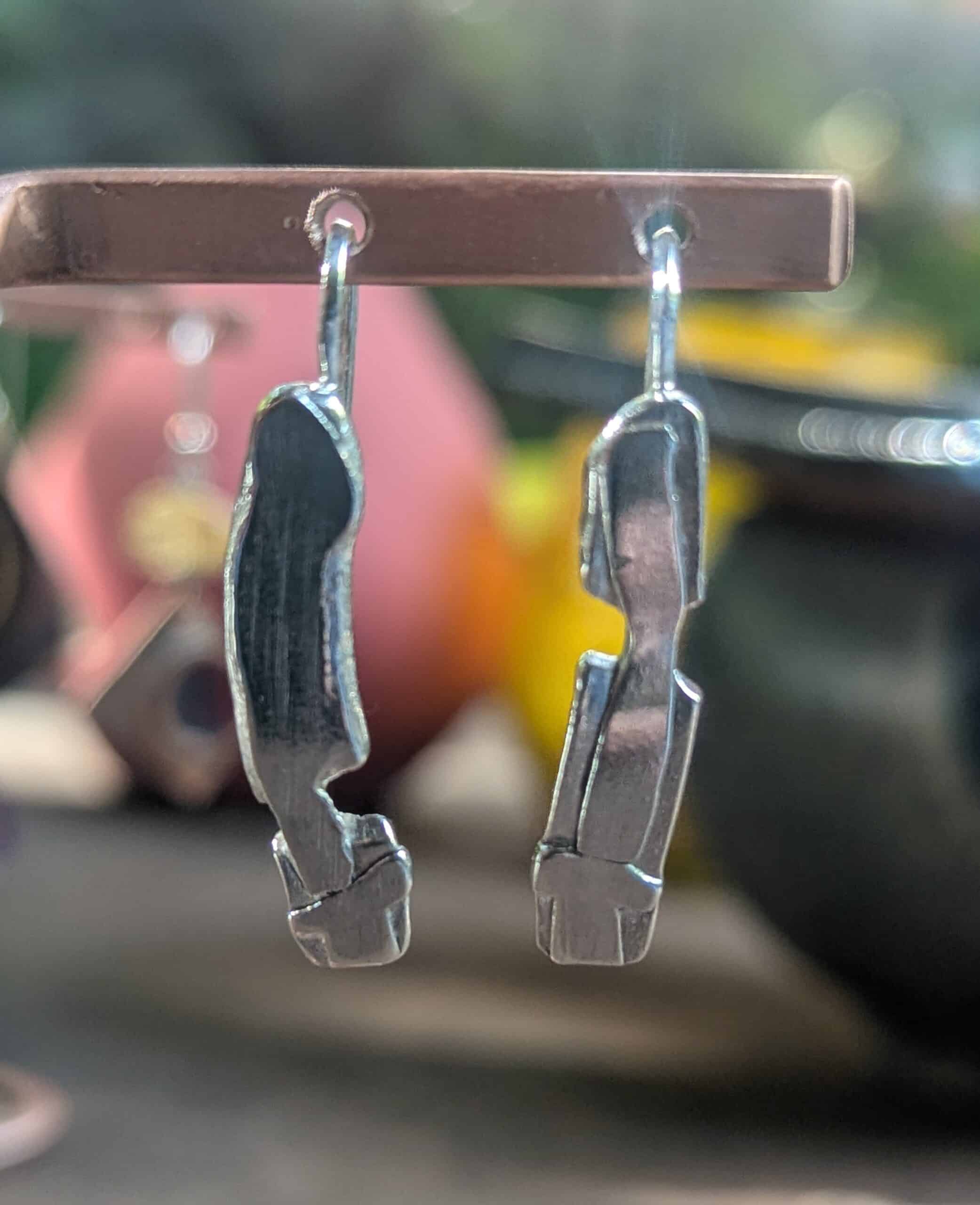 Boucles d’oreilles argent massif – Design abstrait moderne Boucles d'oreilles pendantes en argent massif au design abstrait et moderne suspendues sur un présentoir.